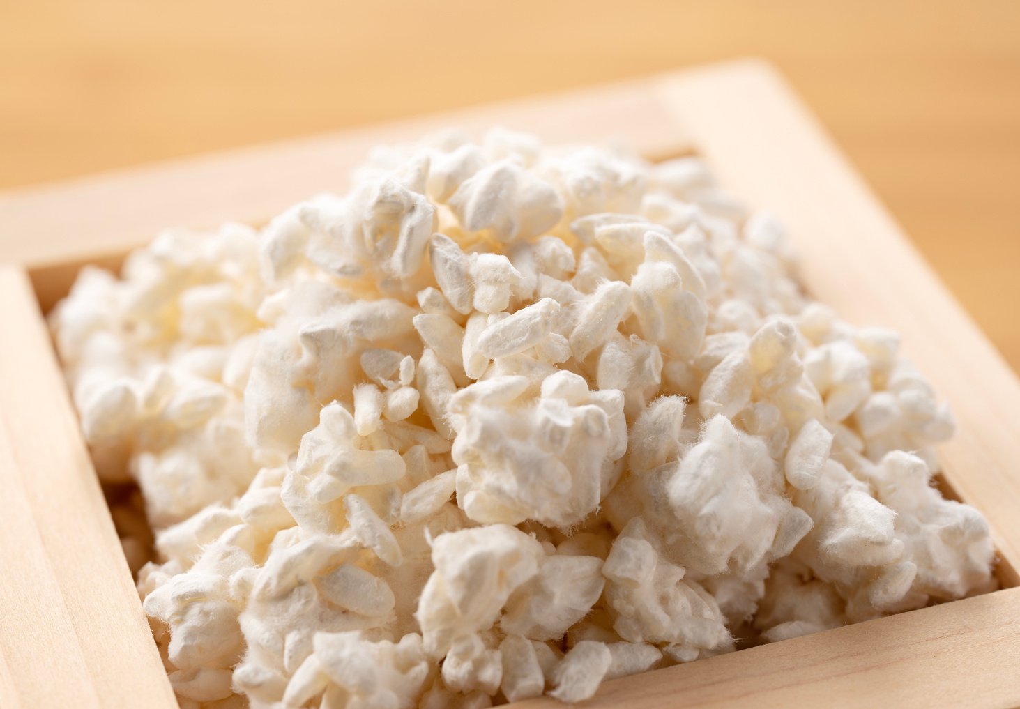 Rice koji in a Masu box placed against a wooden background. Koji